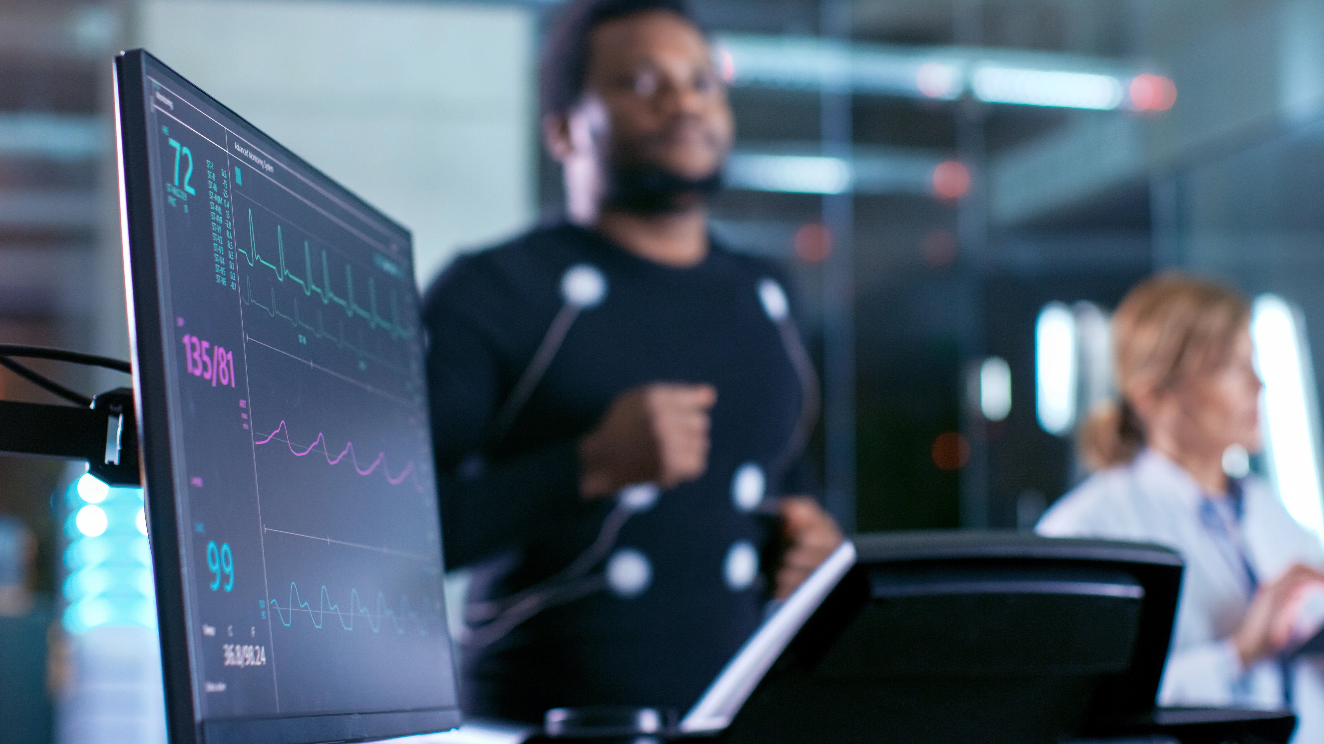 Person working at a computer with multiple monitors displaying data in a blurred office setting